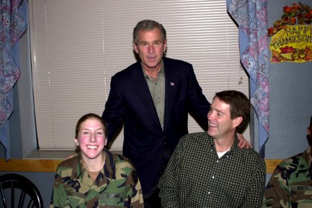 President George W. Bush takes a moment to pose for a photograph with US Army Private First Class Heike Feigh and Senator Bill Frist photo