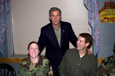 President George W. Bush takes a moment to pose for a photograph with US Army Private First Class Heike Feigh and Senator Bill Frist