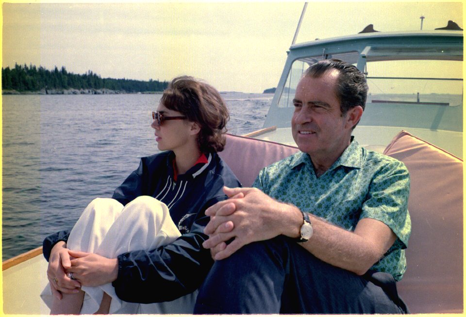 President Richard Nixon and Julie Nixon Eisenhower relax on the prow of the boat Nellie during a cruise near Minot Island