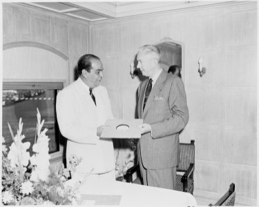 President Romulo Gallegos of Venezuela being presented with a phonograph record by an unknown man, probably aboard... - NARA - 199885