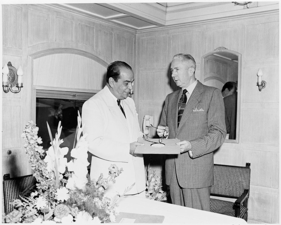 President Romulo Gallegos of Venezuela being presented with a phonograph record by an unknown man, probably aboard... - NARA - 199886