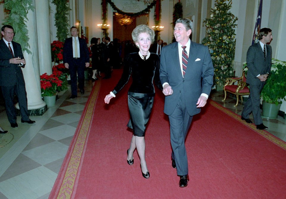 President Ronald Reagan and Nancy Reagan walking down the Cross Hall while attending the Senior Staff Christmas Party