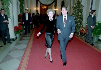 President Ronald Reagan and Nancy Reagan walking down the Cross Hall while attending the Senior Staff Christmas Party