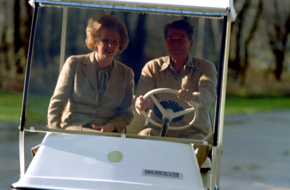 President Ronald Reagan and Prime Minister Margaret Thatcher of United Kingdom at Camp David driving golf cart to Aspen Lodge