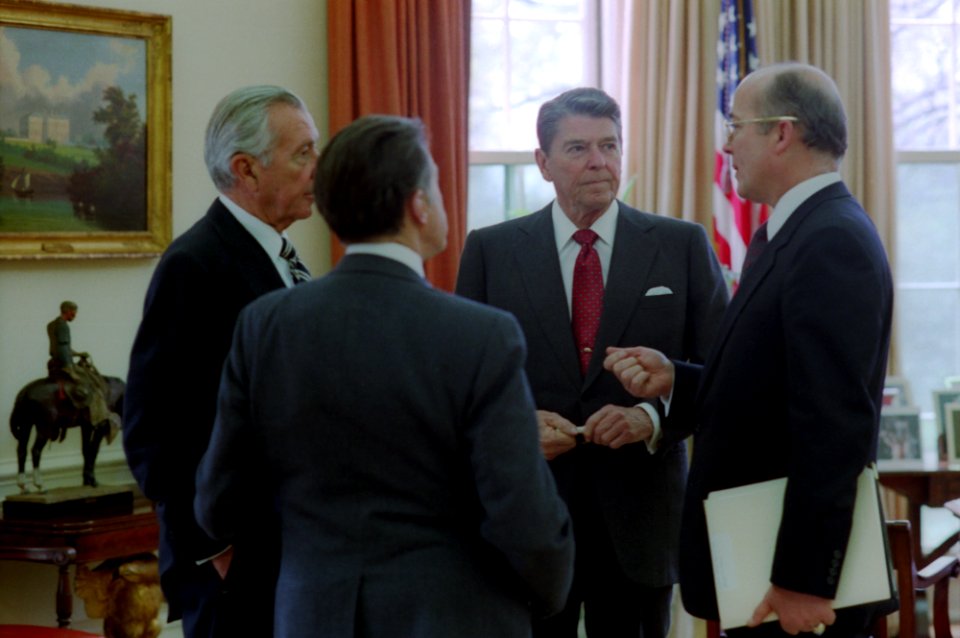 President Ronald Reagan meeting in the Oval Office with staff