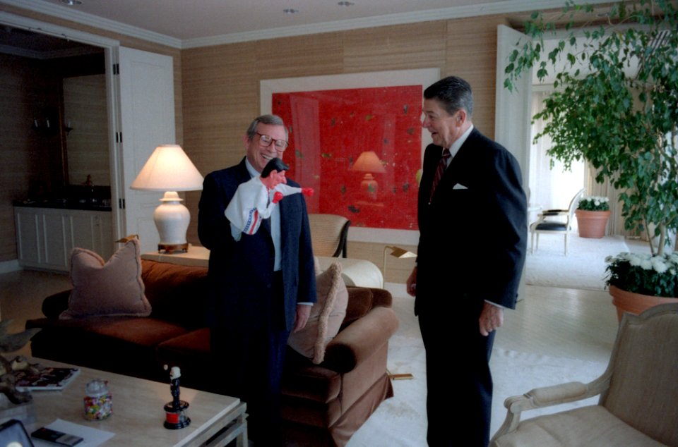 President Ronald Reagan looking at a puppet Howard Baker is holding in his Century Plaza Hotel suite