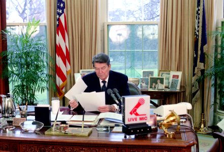 President Ronald Reagan making a radio address to the nation on the federal budget and taxes in the Oval Office photo