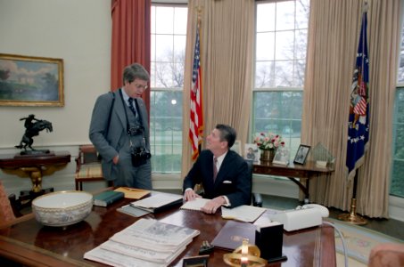President Ronald Reagan meeting with White House photographer Michael Evans in the Oval Office