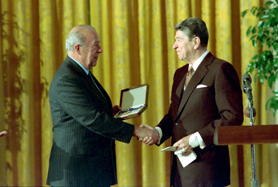 President Ronald Reagan presenting medal to George Shultz during the Medal of Freedom Luncheon in the East Room