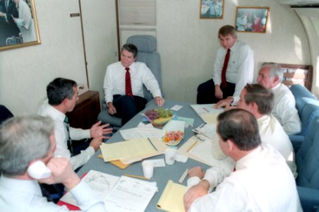 President Ronald Reagan meeting with staff in the lounge aboard Air Force One