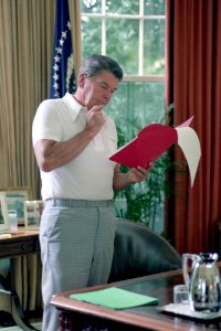 President Ronald Reagan reading during a meeting about the Korean Air Liner KAL 007 crisis in the Oval Office
