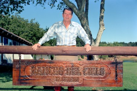 President Ronald Reagan standing above his ranch sign at Rancho Del Cielo
