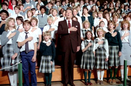 President Ronald Reagan saying the Pledge of Allegiance during a visit to St. Agatha's Catholic High School in Detroit, Michigan