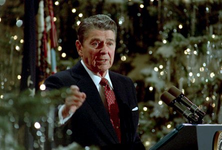 President Ronald Reagan speaking at a podium during his final press conference in the East Room