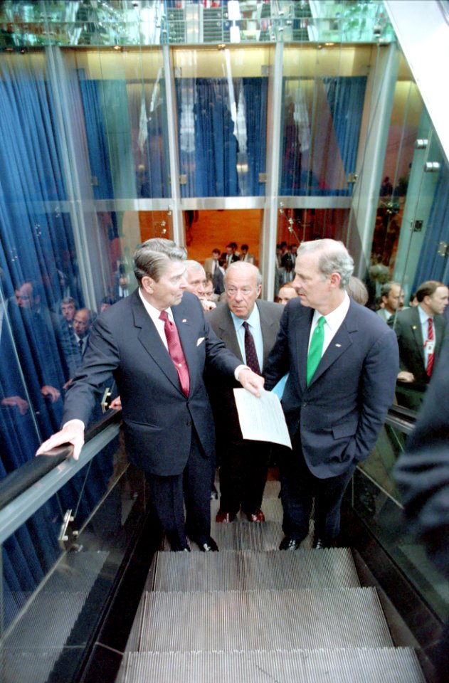 President Ronald Reagan talking to James Baker and George Shultz