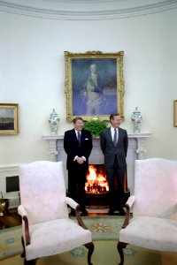 President Ronald Reagan and Vice President George H. W. Bush warming themselves by the fireplace in the Oval Office