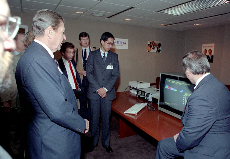 President Ronald Reagan watches a computer demonstration with Richard Wirthlin