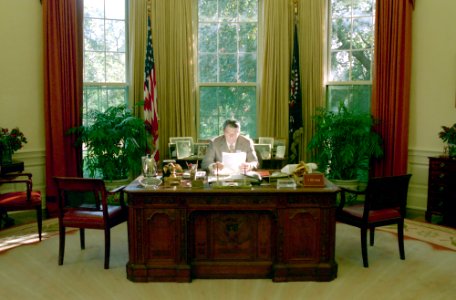 President Ronald Reagan working in the Oval Office photo