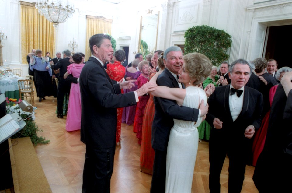 President Ronald Reagan cutting in on Nancy Reagan and Frank Sinatra dancing at the President's birthday party in the East Room