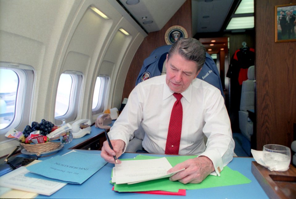 President Ronald Reagan working aboard Air Force One during a trip to California