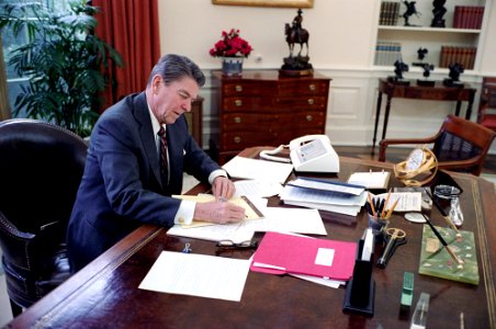 President Ronald Reagan working on the State of the Union Address at his desk in the Oval Office photo