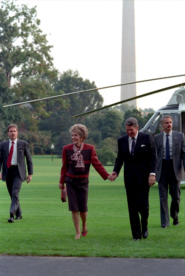 President Ronald Reagan and Nancy Reagan holding hands after arriving back to the White House