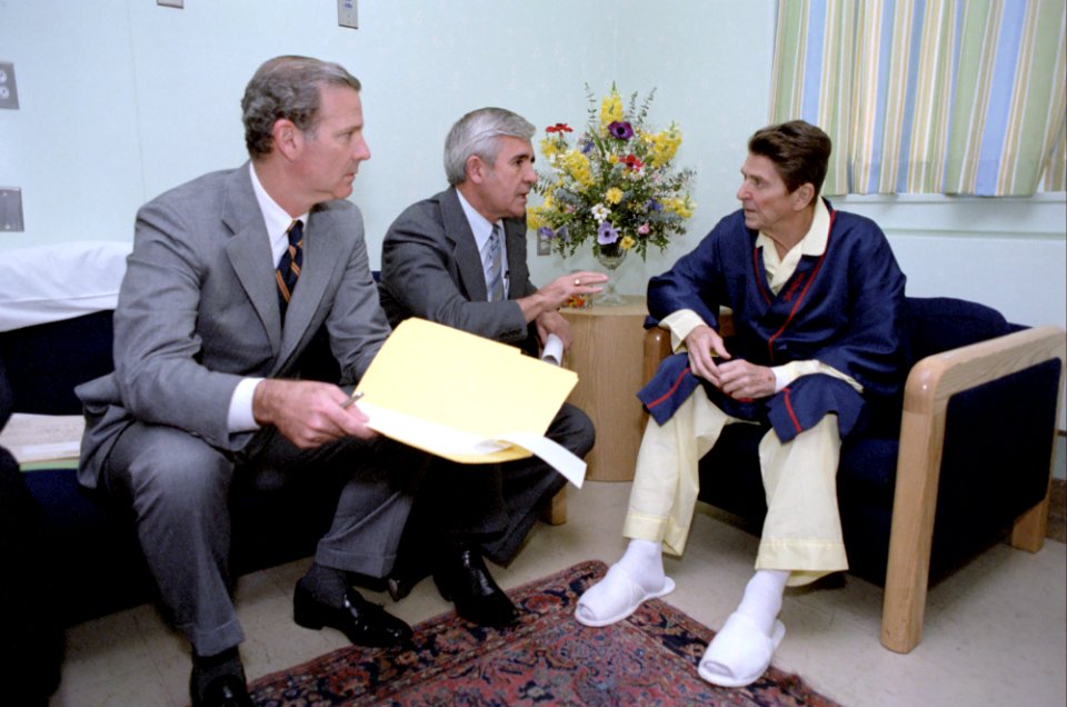 President Ronald Reagan meeting with Senator Paul Laxalt and James Baker at George Washington hospital