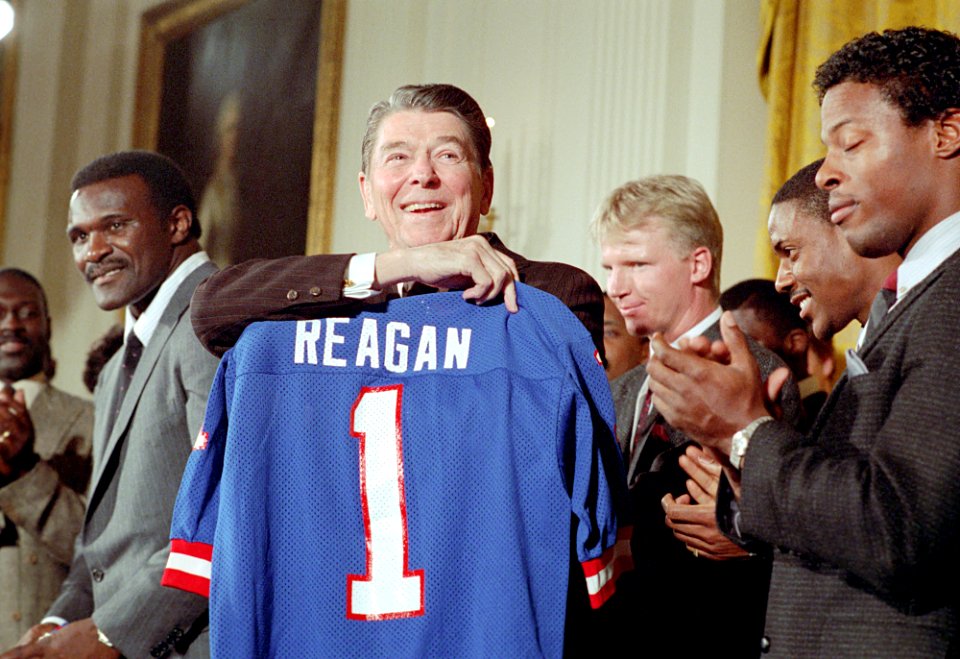 President Ronald Reagan receiving gift during a photo op with the New York Giants football team