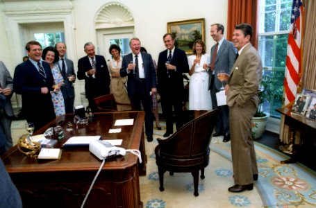 President Ronald Reagan celebrates with his staff in the Oval Office