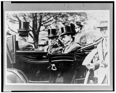 President Woodrow Wilson, center left, wearing top hat, and others seated in open automobile LCCN2002712118