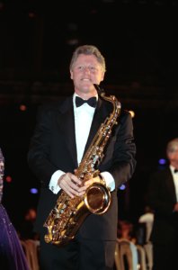 President William J. Clinton a holding a saxophone
