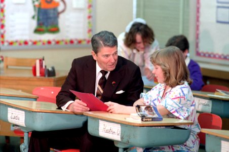 President Ronald Reagan sitting at a desk during a trip to Columbia Missouri and a visit to Fairview Elementary School