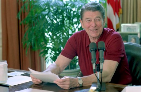 President Ronald Reagan sitting at his desk in the Oval Office, giving a radio address to the nation on International Trade