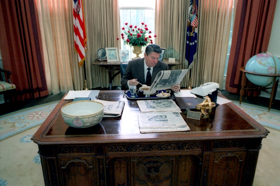 President Ronald Reagan eating lunch at his desk in the Oval Office