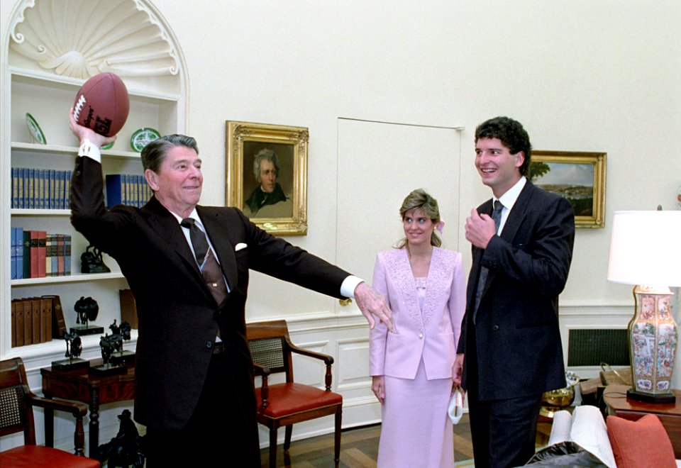 President Ronald Reagan throwing a football during a photo op with football player Bernie Kosar of the Cleveland Browns