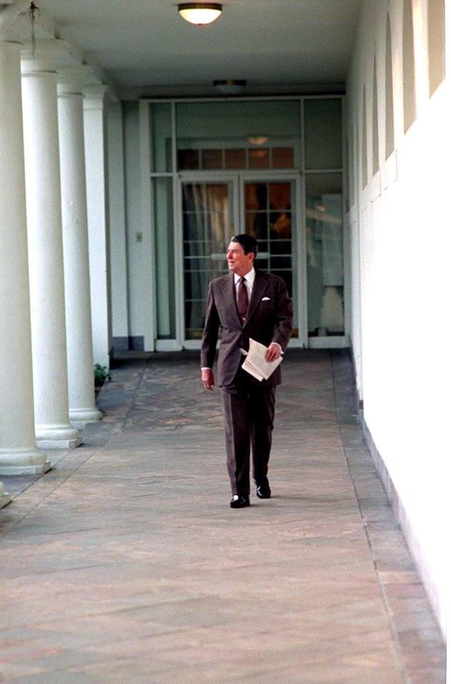 President Ronald Reagan walking alone along the Colonnade