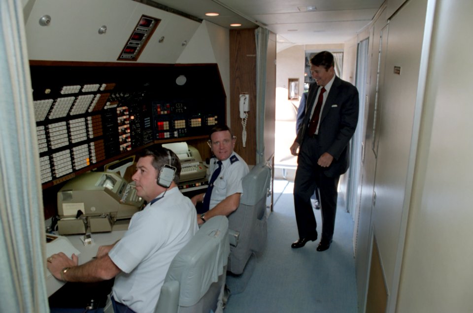 President Ronald Reagan walks by the Communications center aboard Air Force One