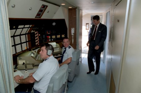 President Ronald Reagan walks by the Communications center aboard Air Force One