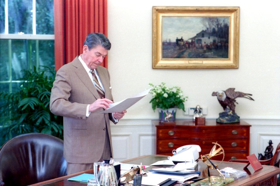 President Ronald Reagan working at his desk in the oval office