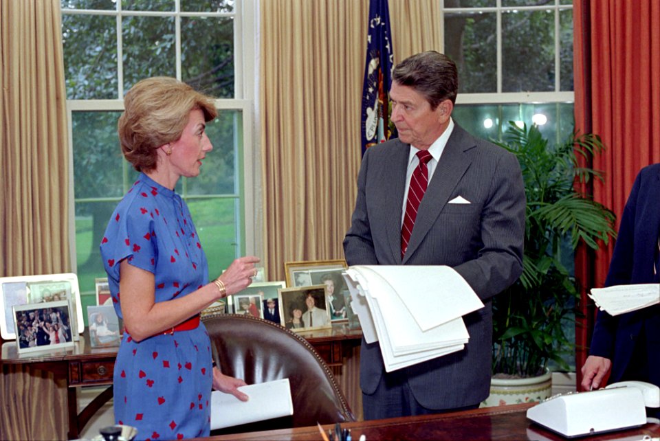 President Ronald Reagan working in the Oval Office with Pamela Turner