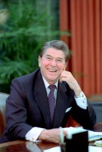 President Ronald Reagan poses at his oval office desk photo
