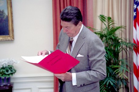 President Ronald Reagan reading a classified file photo