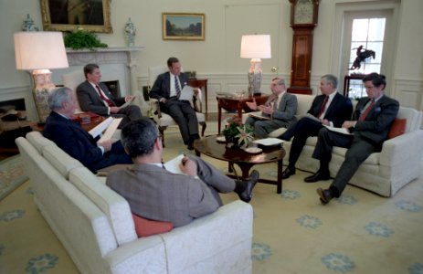 President Ronald Reagan sitting by a fireplace during a National Security Council Briefing