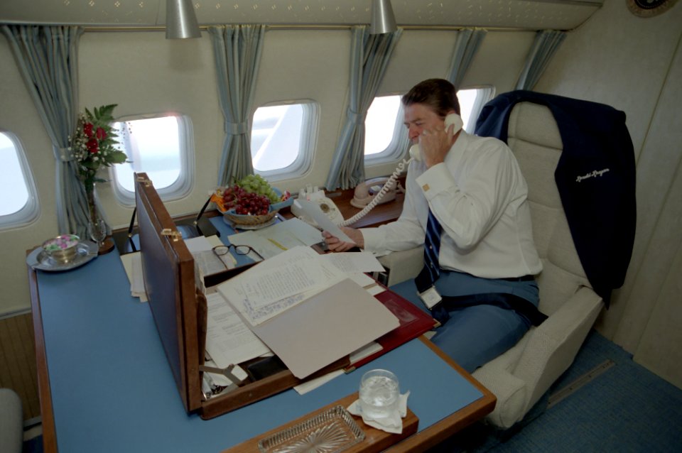 President Ronald Reagan working aboard Air Force One during a trip to Alabama