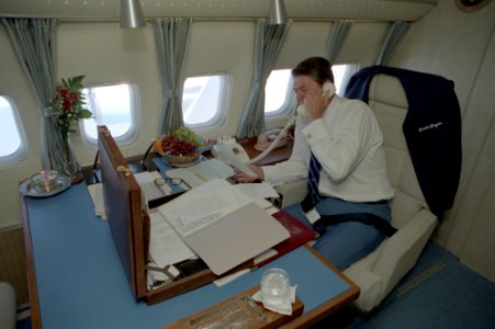 President Ronald Reagan working aboard Air Force One during a trip to Alabama