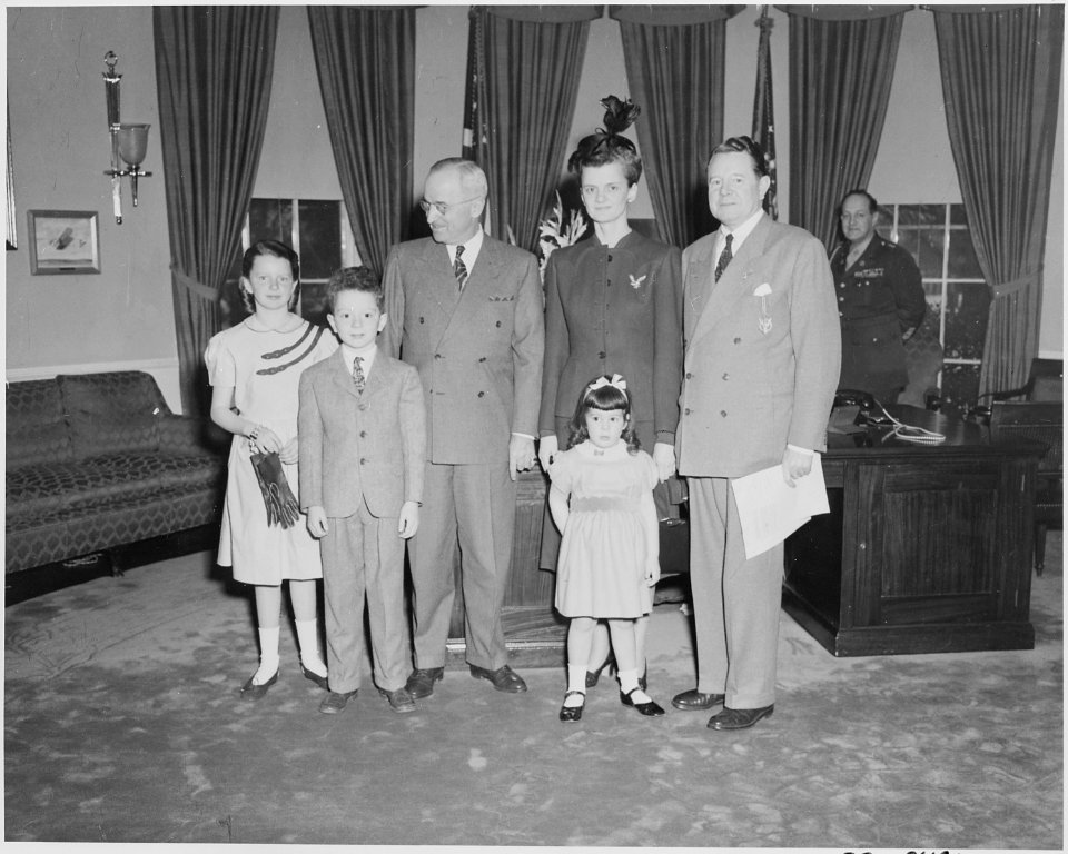 President Truman poses with Secretary of the Navy John L. Sullivan and his family in the oval office. Mr. Sullivan... - NARA - 199636