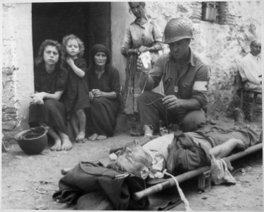 Private Roy Humphrey of Toledo, Ohio, is being given blood plasma by Private First Class Harvey White of Minneapolis... - NARA - 531161