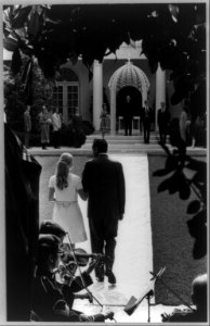 Rear view of Richard Nixon and his daughter, Tricia, during rehearsal for her wedding, in the Rose Garden of the White House; 3 Army violinists in foregrd. LCCN2002707219