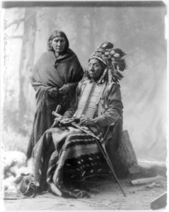 Red Cloud & squaw. (seated, in regalia, holding pipe) LCCN2016647630