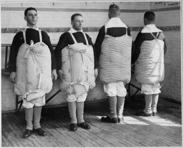 Recruits with their mattresses tied to them to serve as life preservers. Photo taken at Newport Naval Training... - NARA - 533695